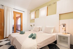 A hotel room with a bed, a nightstand, a lamp, and a view of a hallway. - CASA CAMPILLOS - Villa with private pool and free Wi-Fi in Llucmajor (Llucmajor)
