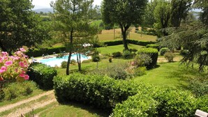 A lush garden with a swimming pool, surrounded by well-maintained hedges and trees. - Wonderful private villa for 16 people with private pool, WIFI, TV, patio and panoramic view (Vicchio)