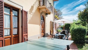 A table tennis table in an outdoor patio area with a building in the background. - Wonderful private villa for 16 people with private pool, WIFI, TV, patio and panoramic view (Vicchio)
