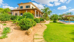 A two-story house with a covered porch, surrounded by well-maintained gardens and a swimming pool. - CAN BOU -  Villa with private pool only 4 km from the beach on the outskirts of Ses saline (Ses Salines)