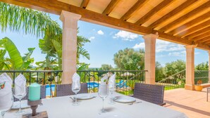 A table set for dining with a view of a pool and tropical plants. - CAN BOU -  Villa with private pool only 4 km from the beach on the outskirts of Ses saline (Ses Salines)