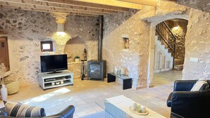A rustic stone interior with a TV, fireplace, and leather seating. - CAN PINA - ECO PINA - Apartment with shared pool in Costitx. Free WiFi (Costitx)