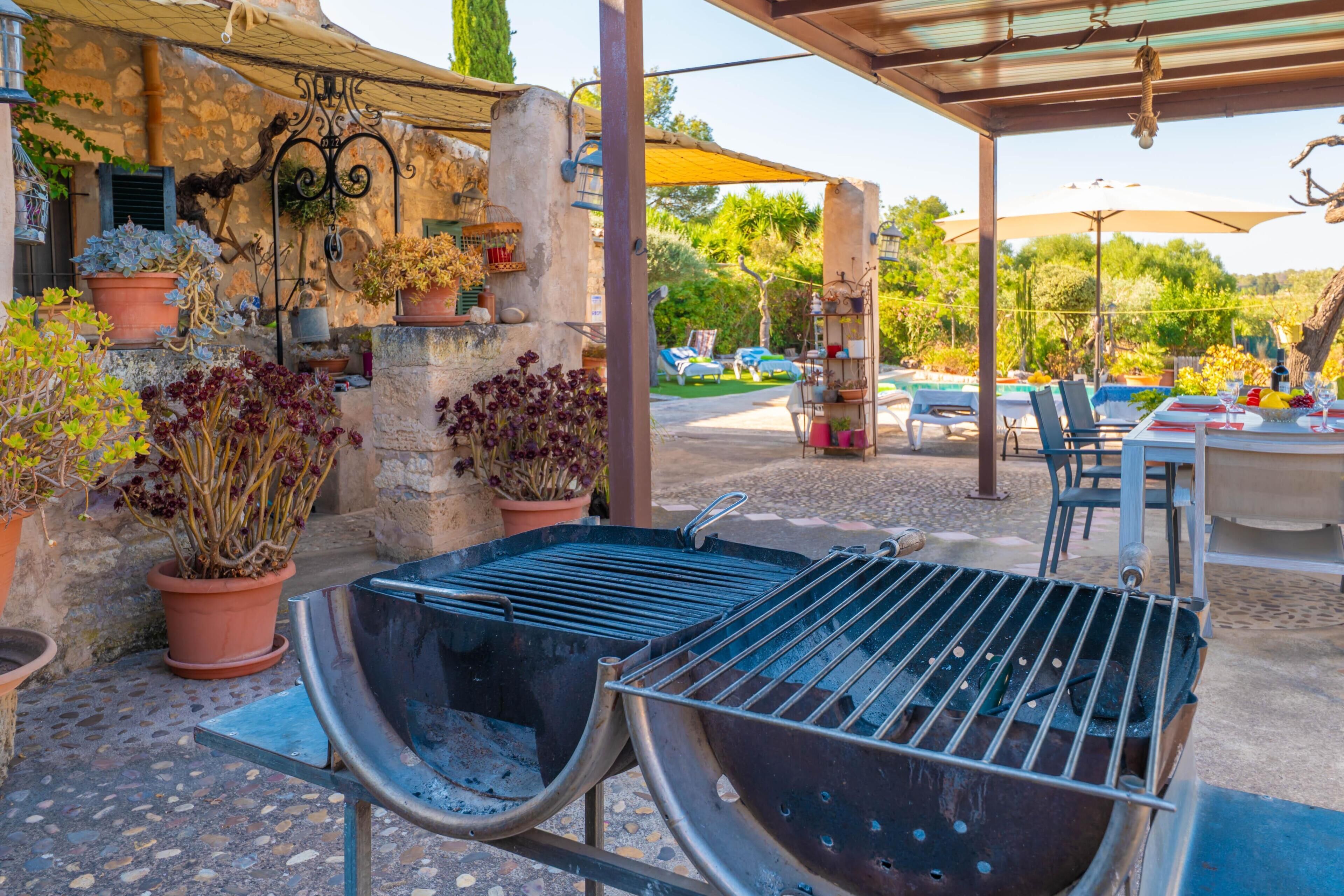 An outdoor patio with a grill, potted plants, and outdoor seating.