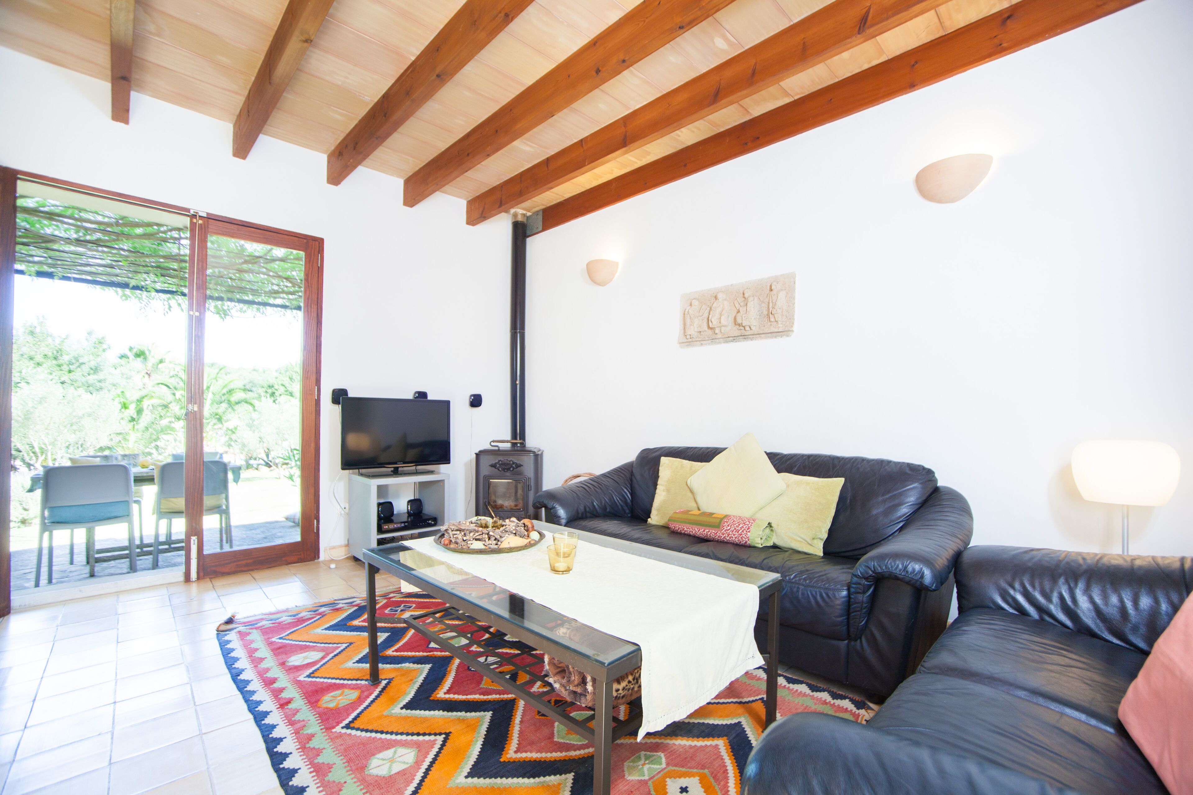 A living room with a sofa, a coffee table, a TV, and a fireplace.