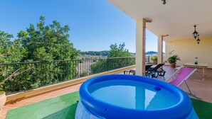 A balcony with a blue inflatable pool, outdoor furniture, and potted plants. - CA'N NADAL - ADULTS ONLY - Beautiful townhouse with great views. Free WiFi. (Sineu)