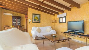 A living room with a sofa, a coffee table, a TV, and a wooden ceiling. - CA'N NADAL - ADULTS ONLY - Beautiful townhouse with great views. Free WiFi. (Sineu)