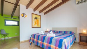 A bedroom with a large bed, a chair, a painting, and a window. - CA'N NADAL - ADULTS ONLY - Beautiful townhouse with great views. Free WiFi. (Sineu)