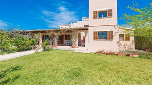 Une maison à deux étages avec un toit plat, un patio couvert et une pelouse bien entretenue.