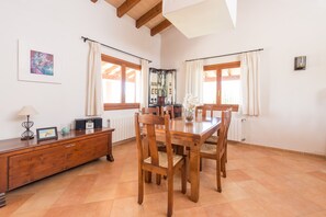 A dining area with a wooden table and chairs, a wooden cabinet, and a radiator.