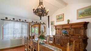 A dining room with a wooden table, chairs, a chandelier, and a wooden cabinet with carvings. - Villa in Vicchio with 4 bedrooms sleeps 8 (Vicchio)