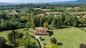 An aerial view of a house surrounded by lush greenery and fields, with a clear sky and distant mountains. - Villa in Vicchio with 4 bedrooms sleeps 8 (Vicchio)