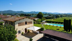 Eine Villa mit Schwimmbad, Außenbereich zum Sitzen und Blick auf Berge.