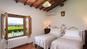 Ein Schlafzimmer mit zwei Betten, Blick auf einen Pool und einer Heizung.