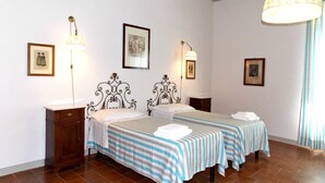 A hotel room with two beds, a wooden nightstand, a lamp, and framed pictures on the wall. - Villa in Scarperia with 2 bedrooms sleeps 4 (Scarperia)
