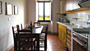A kitchen with a dining table, chairs, a window, and a stove.