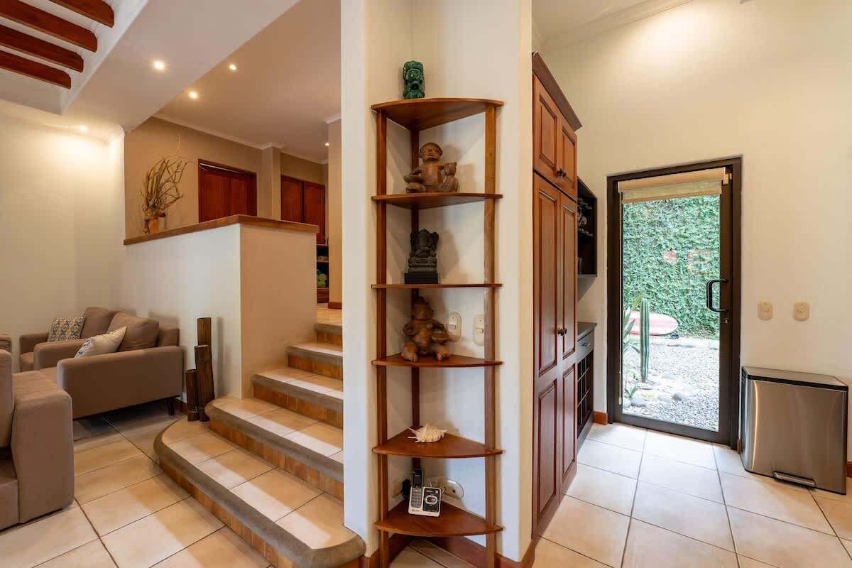 Ein Wohnzimmer mit einer Couch, einem Couchtisch und einer Treppe, die zu einer zweiten Etage führt.