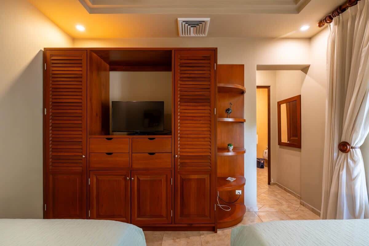 Ein Schlafzimmer mit einem Holftik, einem Fernseher und einem Bett.