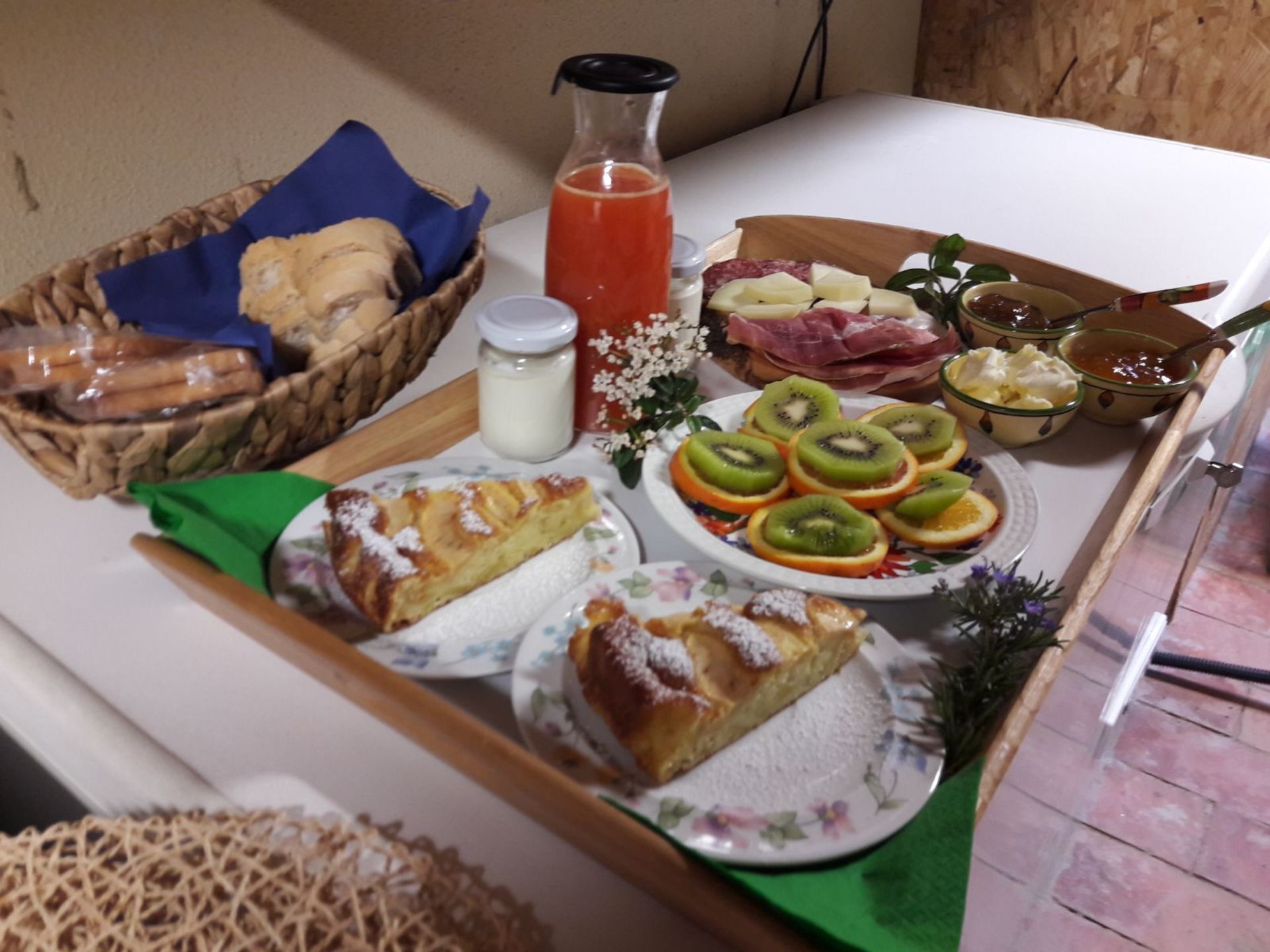 Bandeja de desayuno con pastelería, frutas cortadas y salsas.
