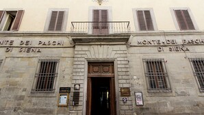 A building facade with the inscription "Monte dei Paschi di Siena" and a wooden door. - Beautiful apartment for 4 people with A/C, WIFI, TV, terrace, pets allowed and panoramic view (Cortona)