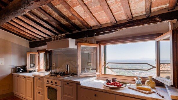 A kitchen with a large window offering a view of the countryside. - Beautiful apartment for 4 people with A/C, WIFI, TV, terrace, pets allowed and panoramic view (Cortona)