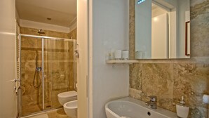 A bathroom with a glass-enclosed shower, two toilets, a sink with a mirror above, and a towel rack. - Capannino - Holiday House Rental near Siena, Tuscany (Ponte A Bozzone)