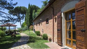 A rustic brick building with a stone pathway leading to a wooden door. - Wonderful  villa for 4 guests with A/C, WIFI, private pool, TV and panoramic view, close to Cort... (La Villa-farneta)