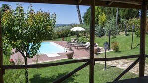 A pool area with a pergola, lounge chairs, and a view of the landscape. - Wonderful  villa for 4 guests with A/C, WIFI, private pool, TV and panoramic view, close to Cort... (La Villa-farneta)