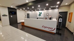 A reception area with a white counter, a digital screen, and a sign for 'Express'.