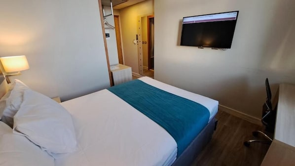 A hotel room with a bed, a desk, a chair, a TV, and a wardrobe. - Diego de Almagro Calama Express (Calama)