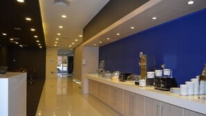 A modern hotel reception area with a long counter, a blue accent wall, and a polished floor.