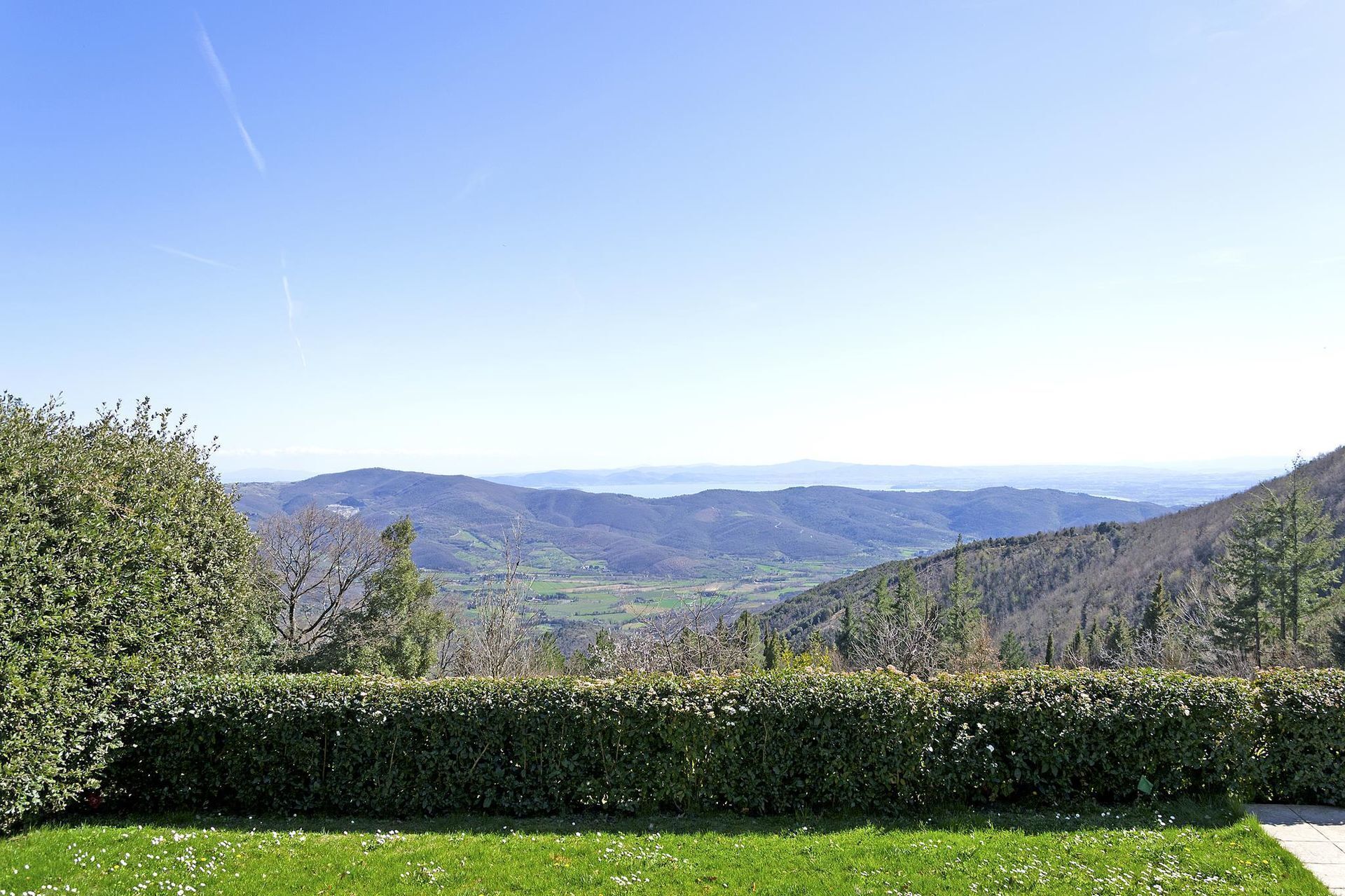 A lush green landscape with rolling hills and a clear blue sky.