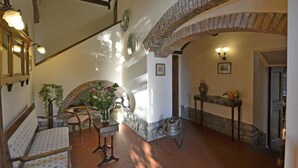 A spacious interior with a staircase, a seating area, and a fireplace.