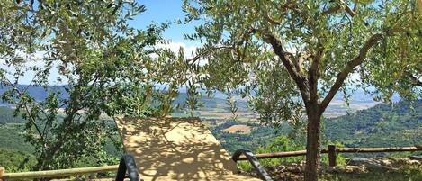 A picnic table with a view of a hilly landscape.