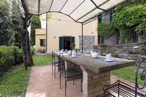 An outdoor patio with a stone table and chairs, a covered area, and a stone staircase. - Private Villa with hot tub, WIFI, sauna, pool, A/C, TV, terrace, panoramic view, close to Cortona (Torreone)