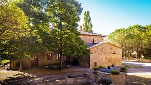 A stone building with a tiled roof, surrounded by trees and outdoor seating. - Private Villa with hot tub, A/C, private pool, WIFI, TV, patio, panoramic view, close to Cortona (Terontola)