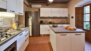 A modern kitchen with stainless steel appliances, white cabinetry, and a large island. - Private Villa with hot tub, A/C, private pool, WIFI, TV, patio, panoramic view, close to Cortona (Terontola)