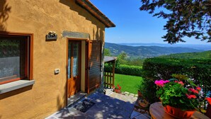 Une maison avec une pancarte «Bienvenue», une porte en bois et une vue sur les montagnes.
