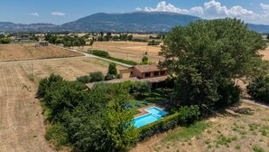 Una villa con piscina immersa nel verde e circondata da campi.