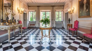 Un vaste hall d’entrée doté d’un sol à carreaux, de meubles richement décorés et d’un décor classique.