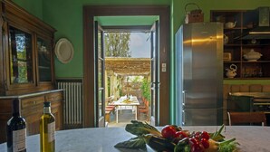 A kitchen with a marble countertop, a refrigerator, and a dining area visible through an open doorway. - Beautiful private villa with private pool, WIFI, A/C, TV, patio and panoramic view, close to Lucca (San Concordio Di Moriano)
