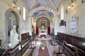 A church interior with arched ceilings, a central altar, and pews arranged in rows.