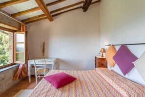 Ein Schlafzimmer mit einem Bett, einem Schreibtisch und einem Fenster.