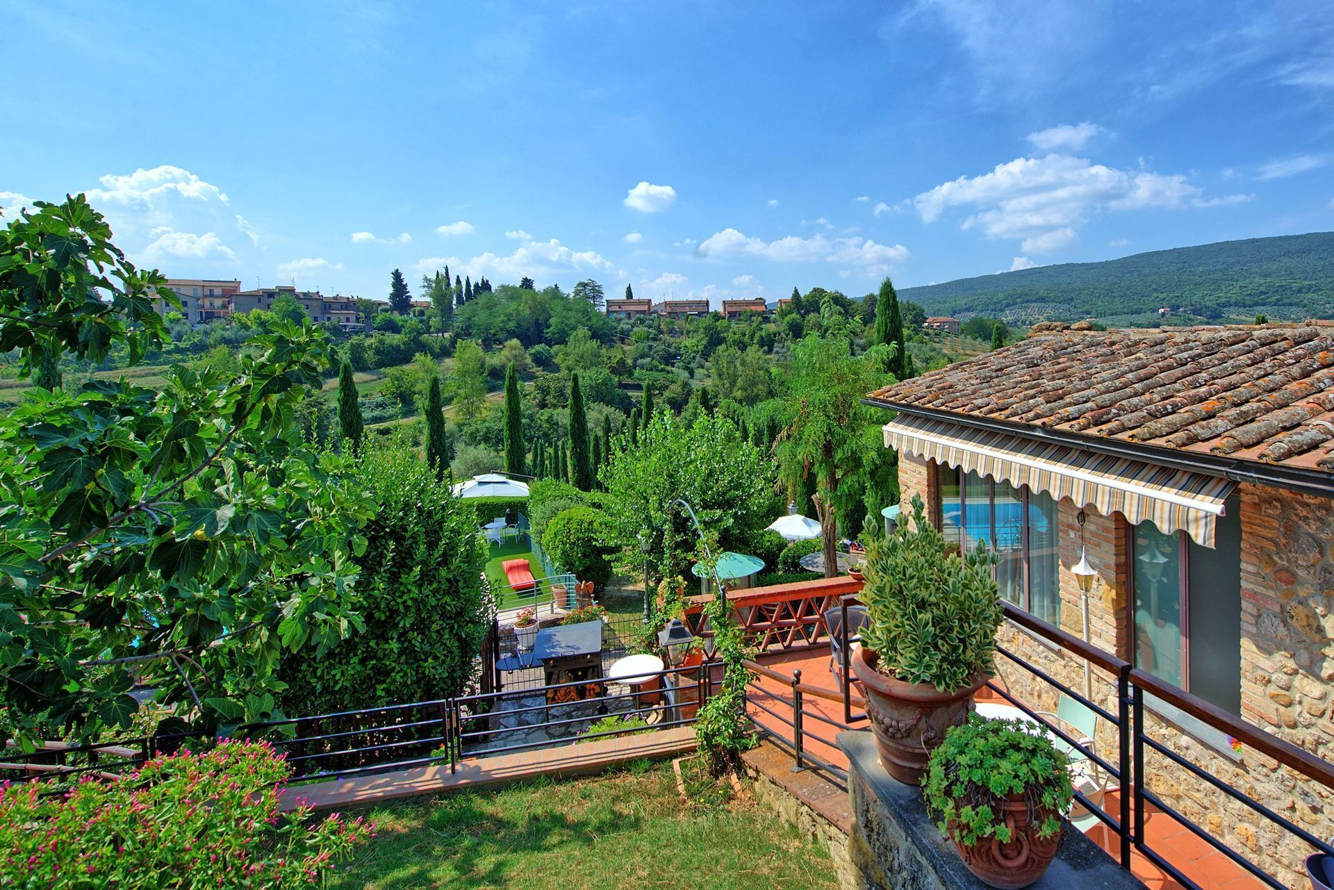 Une villa dotée d’une terrasse donnant sur un jardin luxuriant et un vignoble.