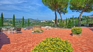 A terrace with outdoor seating, a brick floor, and a view of the countryside. - Beautiful apartment for 2 guests with pool, A/C, WIFI, TV and panoramic view (San Gimignano)