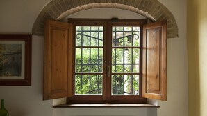 A room with a window featuring wooden shutters and a wrought iron gate. - Cosy apartment for 3 people with pool, A/C, WIFI, pets allowed and panoramic view (San Gimignano)