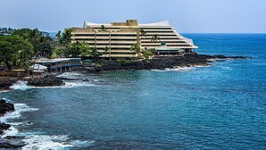 A hotel with a modern design, located near a rocky coastline with ocean views. - 🏖️Oceanfront Aliʻi Drive Condo w/ A/C | Walk to Town (Kailua Kona)