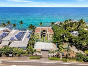 A coastal property with multiple buildings, solar panels on rooftops, and a view of the ocean.