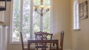A dining area with a chandelier, a table with chairs, and a decorative sign above the table. - HISTORIC DISTRICT ~ Walk Everywhere ~ Private Parking! (St. Augustine)