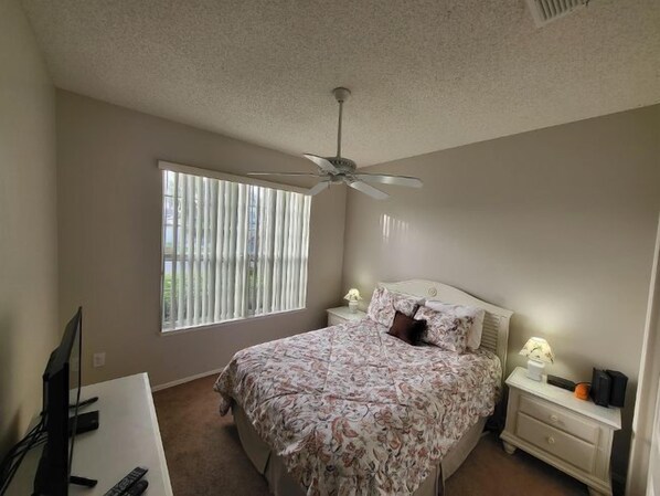 A bedroom with a bed, a nightstand, a desk, and a ceiling fan. - Lovely Pool Home, Pets considered. Orlando 1744 (Orlando)