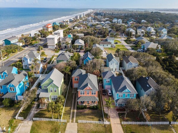 A residential area with houses, a beach, and a road.